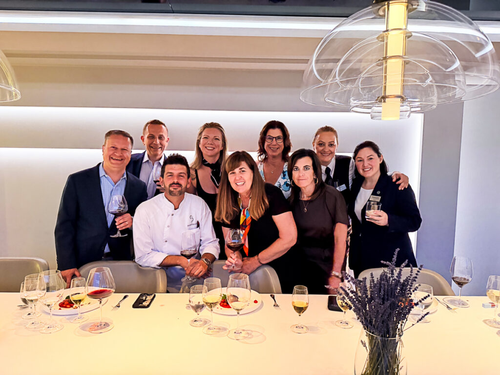 group of cruisers with head chef, sommelier, and dining manager in The Vintage Room on Riverside Ravel